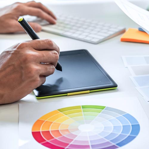 graphic designer using graphic tablet and color chart